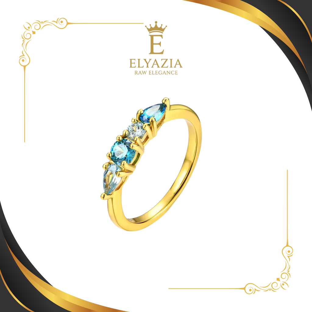 Gold ring with blue gemstones on a white background with Elyazia branding.