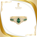Gold ring with green gemstones on a white background with Elyazia logo