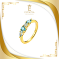Gold ring with blue gemstones on a white and gold background with Elyazia logo